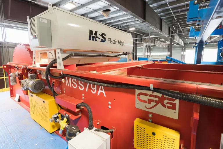 Image of an orange PlasticMax optical sorter in a warehouse.