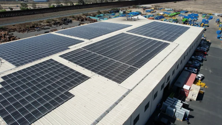 Exterior drone image of a manufacturing building with solar panels on the roof.